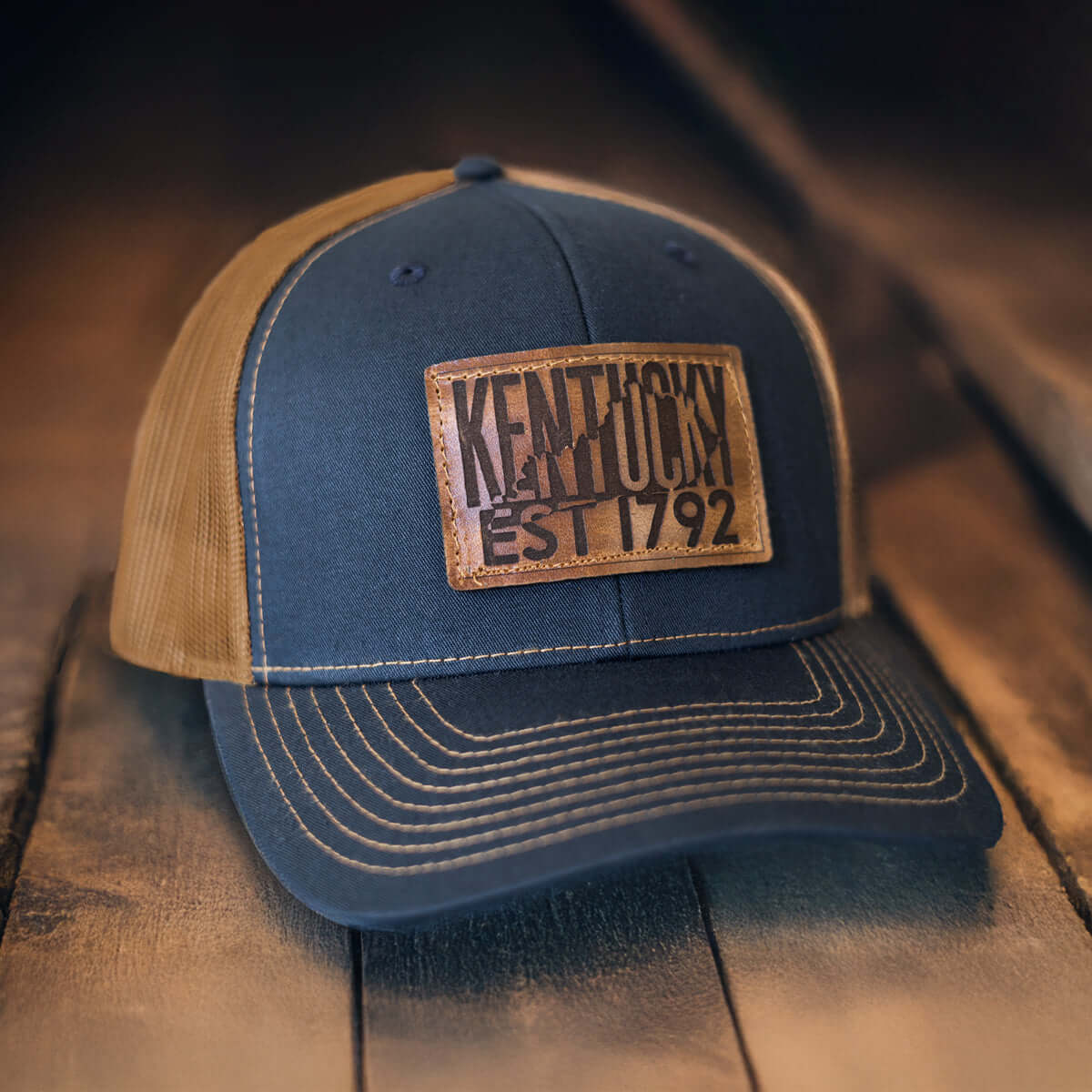Kentucky 1792 whiskey hat in navy blue and caramel with genuine leather patch, classic trucker style.