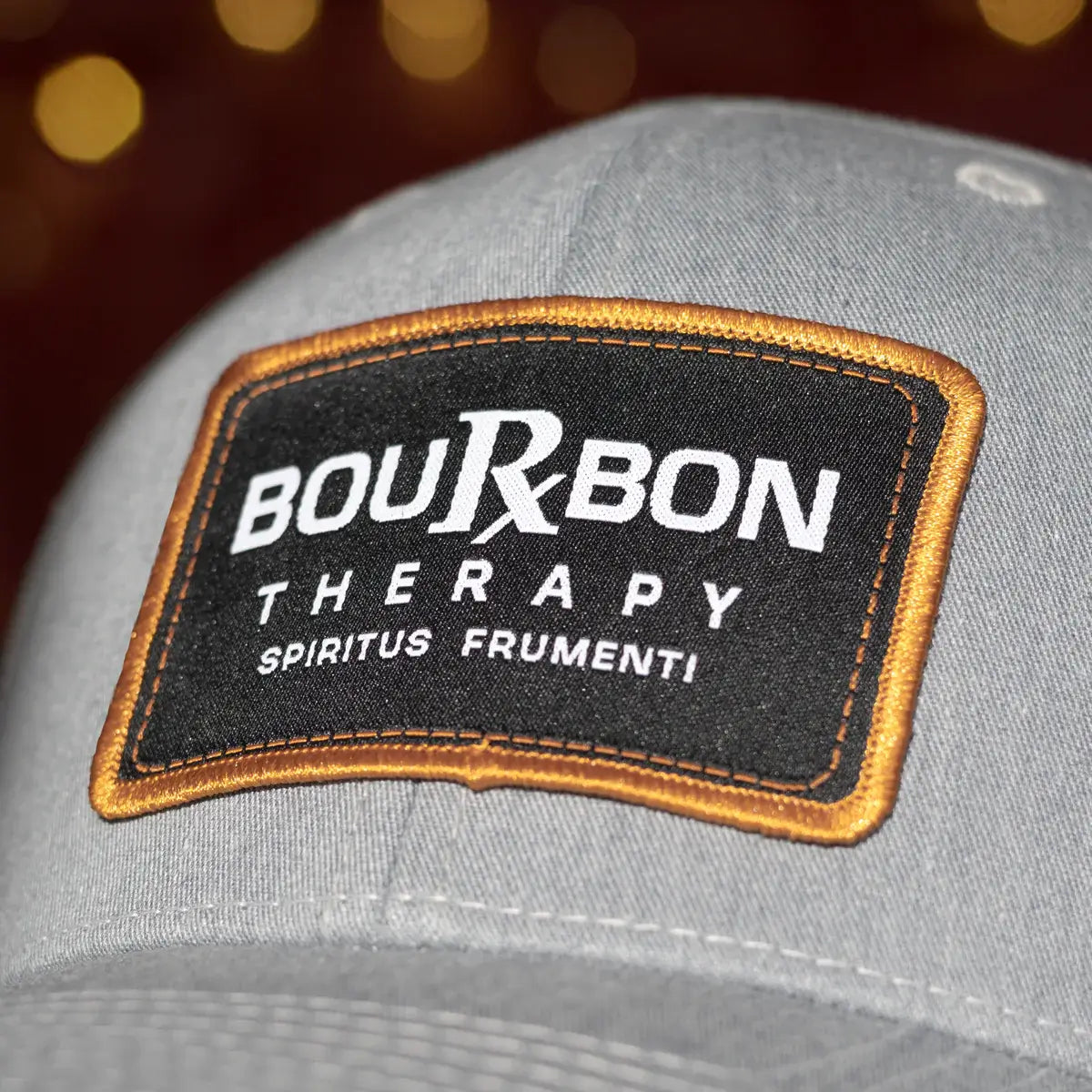 Gray cap with a Bourbon Therapy patch on a blurred background