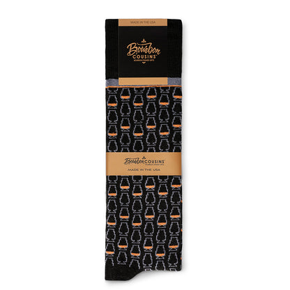 black bourbon socks with a whiskey glass pattern neatly folded with bourbon cousins branding