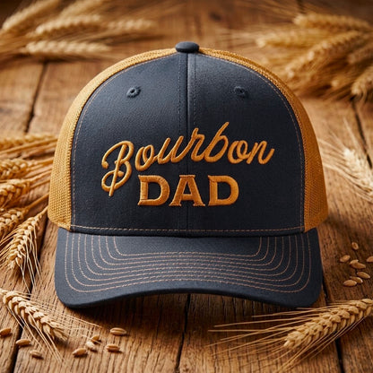 Bourbon Dad Trucker Hat in navy and caramel featuring bold embroidered text on a rustic wooden background.