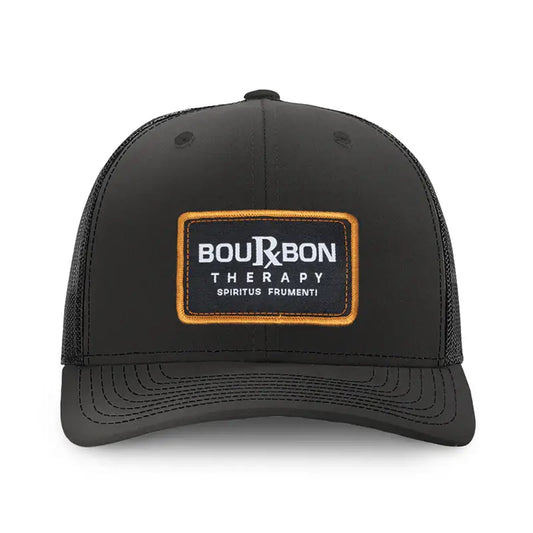 Black Richardson 112 hat with a woven patch logo that reads bourbon therapy