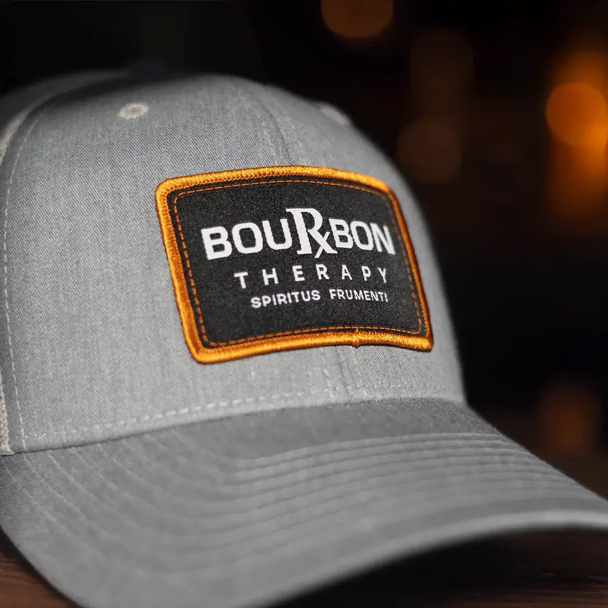 Gray Richardson 112 hat with a Bourbon Therapy patch on a blurred background