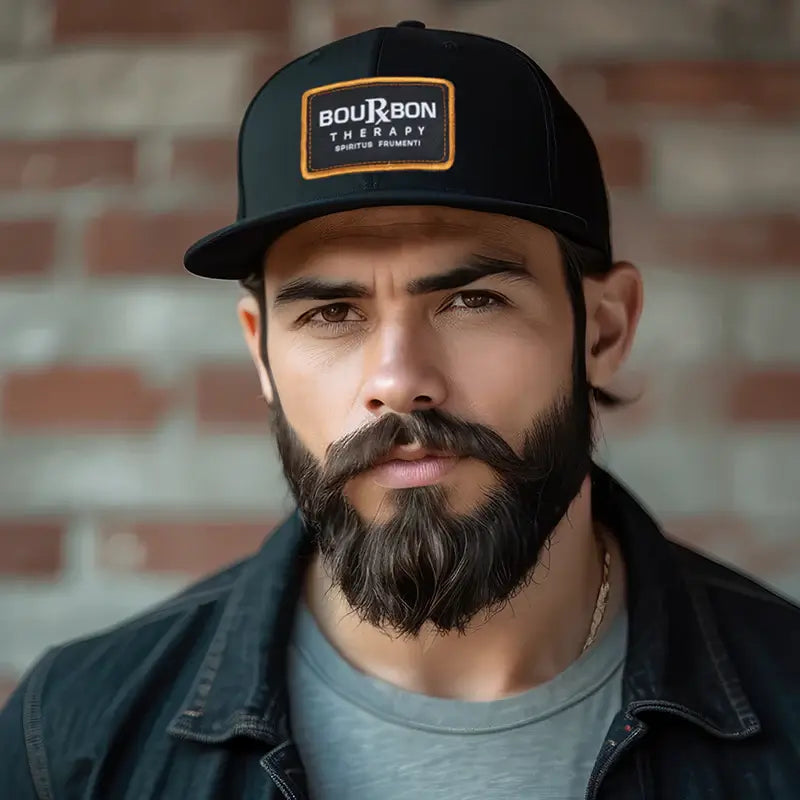 bearded man wearing a black richardson 112 hat with a bourbon therapy patch