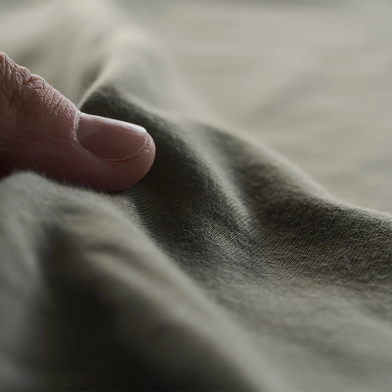 Close-up of a hand resting on a textured fabric surface
